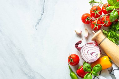 Sebzeler, otlar ve baharatlarla dolu beyaz mermer bir masa. Kopyalama alanı olan üst görünüm.