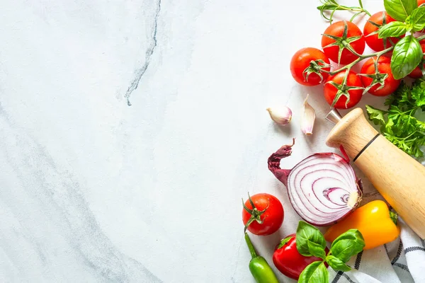 Sebzeler, otlar ve baharatlarla dolu beyaz mermer bir masa. Kopyalama alanı olan üst görünüm.