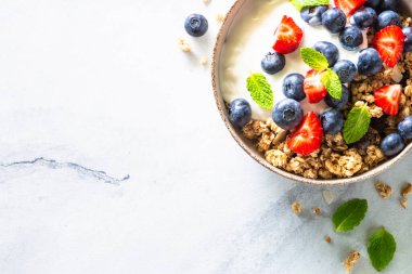 Tahıllı Yunan yoğurdu ve mermer masada taze böğürtlen. Kopyalama alanı olan üst görünüm.