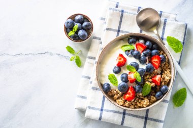 Tahıllı Yunan yoğurdu ve mermer masada taze böğürtlen. Kopyalama alanı olan üst görünüm.