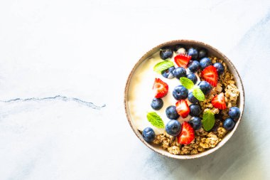 Tahıllı Yunan yoğurdu ve mermer masada taze böğürtlen. Kopyalama alanı olan üst görünüm.