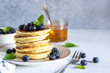 Beyaz masada taze yaban mersinli krep ve bal..