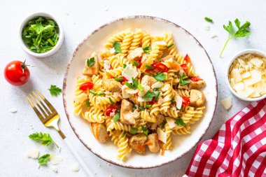 Hindi, tavuk, sebze ve parmesanlı makarna. Üst görünüm beyaz.
