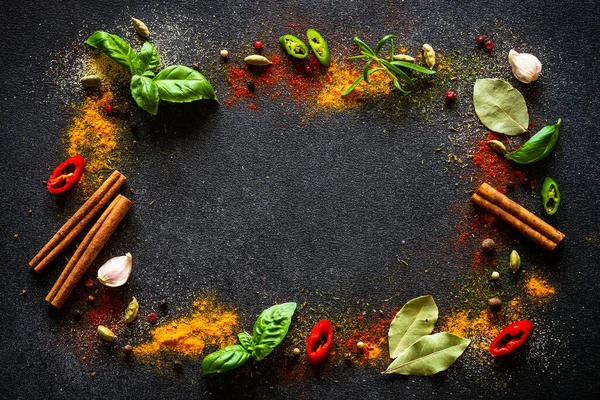 Siyah arka planda baharatlar ve bitkiler. Biber, turmelik, dereotu, tarçın, fesleğen, biberiye, soğuk kakule. Kopyalama alanı olan üst görünüm.