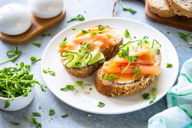 Krem peynirli, somonlu ve salatalıklı sandviç. Sağlıklı kahvaltı ya da atıştırmalık. Kapat..