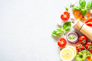 Beyaz arka planda taze sebzeler ve bitkiler. Yemek yapmak için gerekli malzemeler. Kopyalama alanı olan üst görünüm.