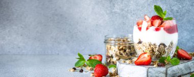 Kremalı ya da yoğurtlu parfüm, reçel ve cam kavanozda taze çilek. Uzun pankart biçimi.