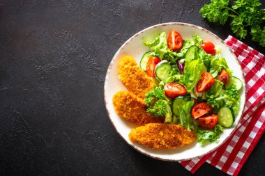 Koyu taş masada taze salatalı tavuk nugget. Kopyalama alanı olan en üst görüntü.