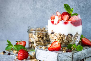 Kremalı ya da yoğurtlu parfüm, reçel ve cam kavanozda taze çilek. Kapat..