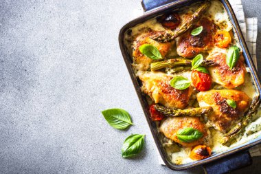 Kuşkonmaz ve soslu domatesli fırında tavuk butları. Makro.