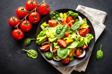 Siyah tabak içinde taze salata. Vejetaryen yemeği. Kopyalama alanı olan üst görünüm.