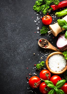 Yemek arkaplanı siyah taş masa. Taze sebzeler, otlar ve baharatlar. Fotokopi alanı ile pişirme malzemeleri.