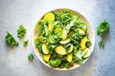 Salatalıklı lahana salatası ve el yapımı tabakta avokado. Üst görünüm.