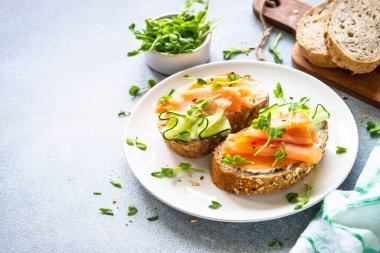 Krem peynirli, somonlu ve salatalıklı sandviç. Sağlıklı kahvaltı ya da atıştırmalık. Kapat..