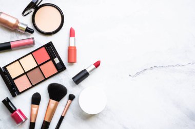 Makyaj malzemeleri, beyaz mermer arka planda profesyonel kozmetik ürünleri. Ruj, pudra, fırça. Kopyalama alanı olan düz.