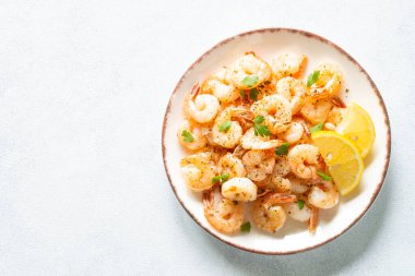 Beyaz taş masadaki baharatlı karidesler. Metin için boşluk olan üst görünüm.