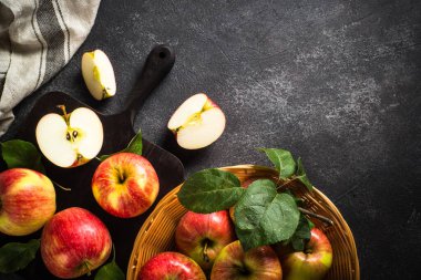 Taze olgun elmalar, siyah taş masada bütün ve dilimlenmiş elmalar. Üst görünüm.