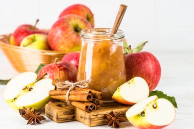 Baharatlı elma reçeli ve beyaz arkaplanda taze elma.