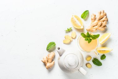 Limonlu zencefil çayı ve malzemeli cam bardakta nane. Metin için boşluk olan beyaz tabloda en üstteki görünüm.