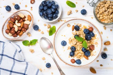 Tahıllı yoğurt ve taş masada taze meyveler. Kopyalama alanı olan üst görünüm. Sağlıklı yemek, atıştırmalık ya da kahvaltı.