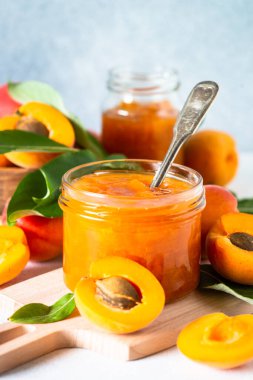 Apricot jam in glass jar with fresh apricots. Homemade preservations.