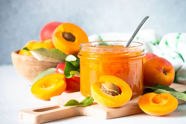Apricot jam in glass jar with fresh apricots. Homemade preservations.