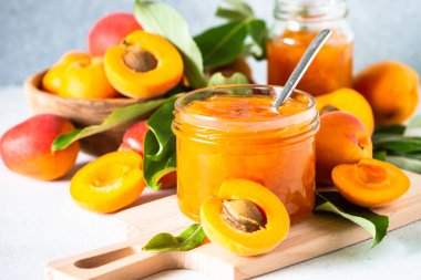 Apricot jam in glass jar with fresh apricots. Homemade preservations.
