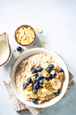 Beyaz arka planda fındıklı yulaf ezmesi ve böğürtlen kabı. Üst görünüm.