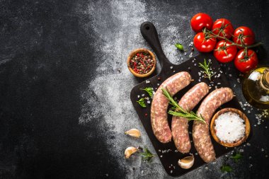 Domuz sucuğu ya da siyah masada baharatlı sosis dilimleme tahtası. Yemek yapmaya hazırım. Kopyalama alanı olan üst görünüm.