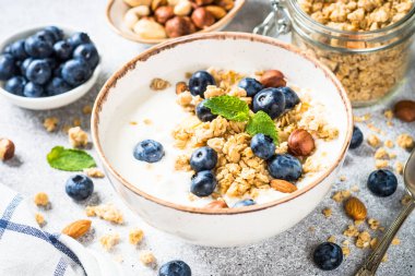 Tahıllı yoğurt ve beyaz masada taze böğürtlen. Sağlıklı yemek, atıştırmalık ya da kahvaltı.