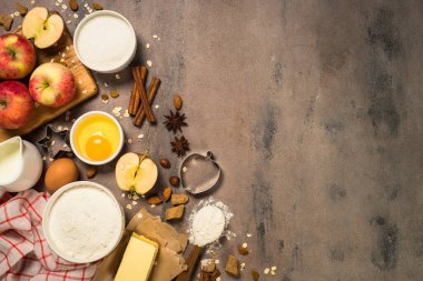 Baking ingredients for cooking autumn baking. Flour, sugar, butter, egg, apples and spices. Top view with copy space.