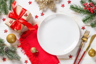 Noel süslemeleri ve beyaz ahşap masada önceden ayarlanmış kutuyla Noel masası. Üst görünüm.