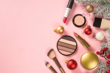 Make up cosmetic products and christmas decorations at pink. Flat lay image with copy space. Chrismas sale and christmas gift concept.