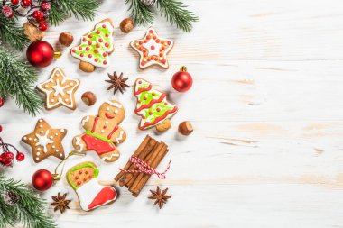 Christmas gingerbread with decorations on white wooden table. Christmas baking. Top view with copy space.