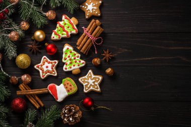 Christmas gingerbread cookies with spices on dark wooden table. Homemade christmas food. Top view with copy space.