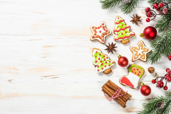 Christmas gingerbread with decorations on white wooden table. Christmas baking. Top view with copy space.