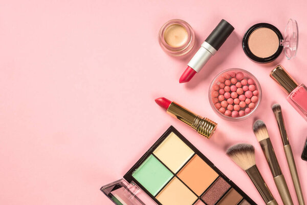 Beauty products. Make up products at pink background. Eye shadow, powder, lipstick for professional make up. Top view image with copy space.