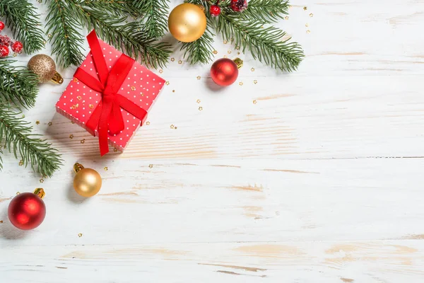赤いリボンと休日の装飾が施されたクリスマスプレゼントボックス 白木のテーブルの上からの眺め — ストック写真