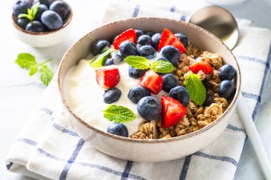 Beyaz masada gevrek ve taze böğürtlenli Yunan yoğurdu.