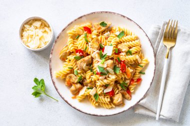 Hindi, tavuk, sebze ve parmesanlı makarna. Üst görünüm beyaz.