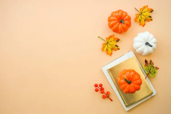 Autumn office workspace. Autumn flat lay background. Keyboard, laptop with autumn cloth and fall decorations - pumpkin, leaves and other.