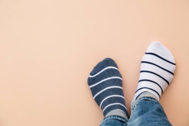 Çorap günü konsepti. Mavi arka planda farklı çoraplar içinde bacaklar. Üst görünüm.