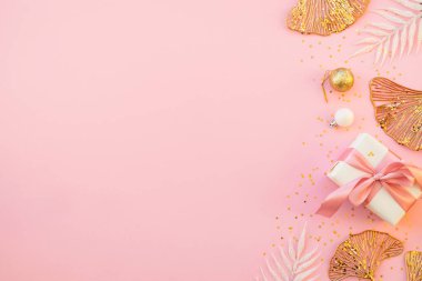 Pembe noel kompozisyonu düzdü. Hediye kutusu, altın dekor ve konfeti. Kopyalama alanı ile düzenName.