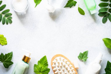 Natural cosmetics concept. Skin care product, cream, serum, soap, mask with green leaves. Flat lay image on white with space for text.