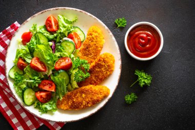 Siyah arka planda taze salatalı tavuk külçeleri. Kopyalama alanı olan en üst görüntü.