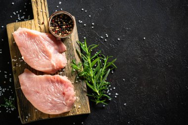 Siyah taş masadaki ahşap kesme tahtasındaki baharatlı biftek ya da fileto. Kopyalama alanı olan üst görünüm.