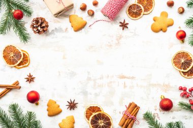 Noel arkaplanı zencefilli ekmek, baharat ve beyaz üzerine köknar ağacı olan bayram süslemeleri. Kopya alanı olan düz konum.