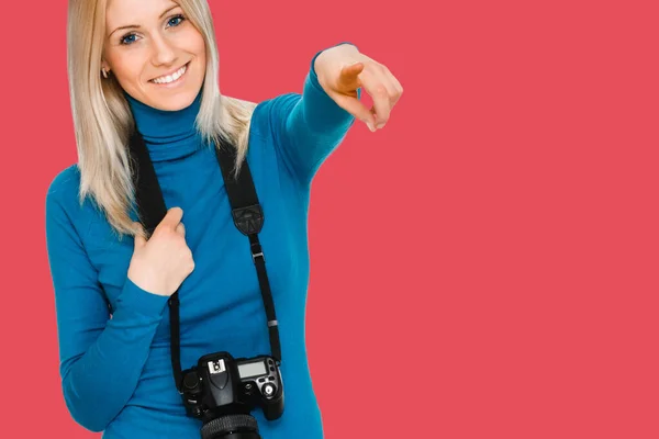Όμορφη γυναίκα κρατώντας μια φωτογραφική μηχανή και δείχνοντας — Φωτογραφία Αρχείου