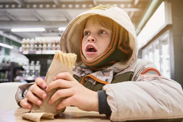 Мальчик ест закуску — стоковое фото