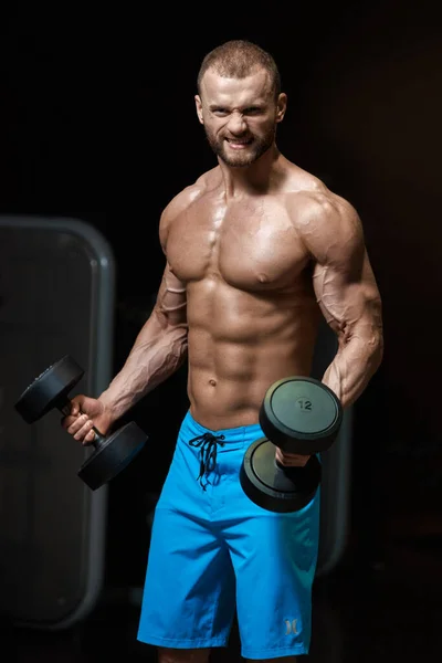 Uomo muscoloso con manubri — Foto Stock
